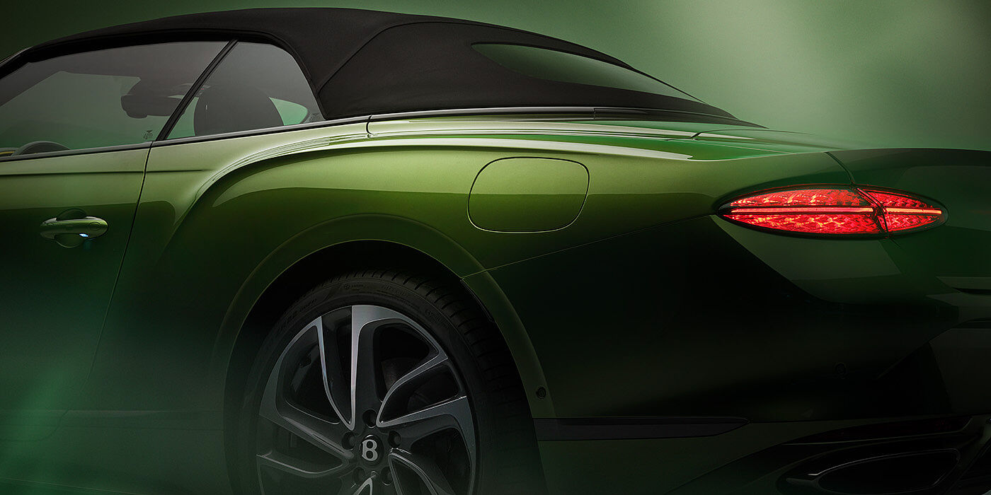 Bentley Kuwait Bentley New Continental GTC Speed rear haunch and tail lamp in Tourmaline Green paint and dark tint brightware with black hood up and illuminated head lamps