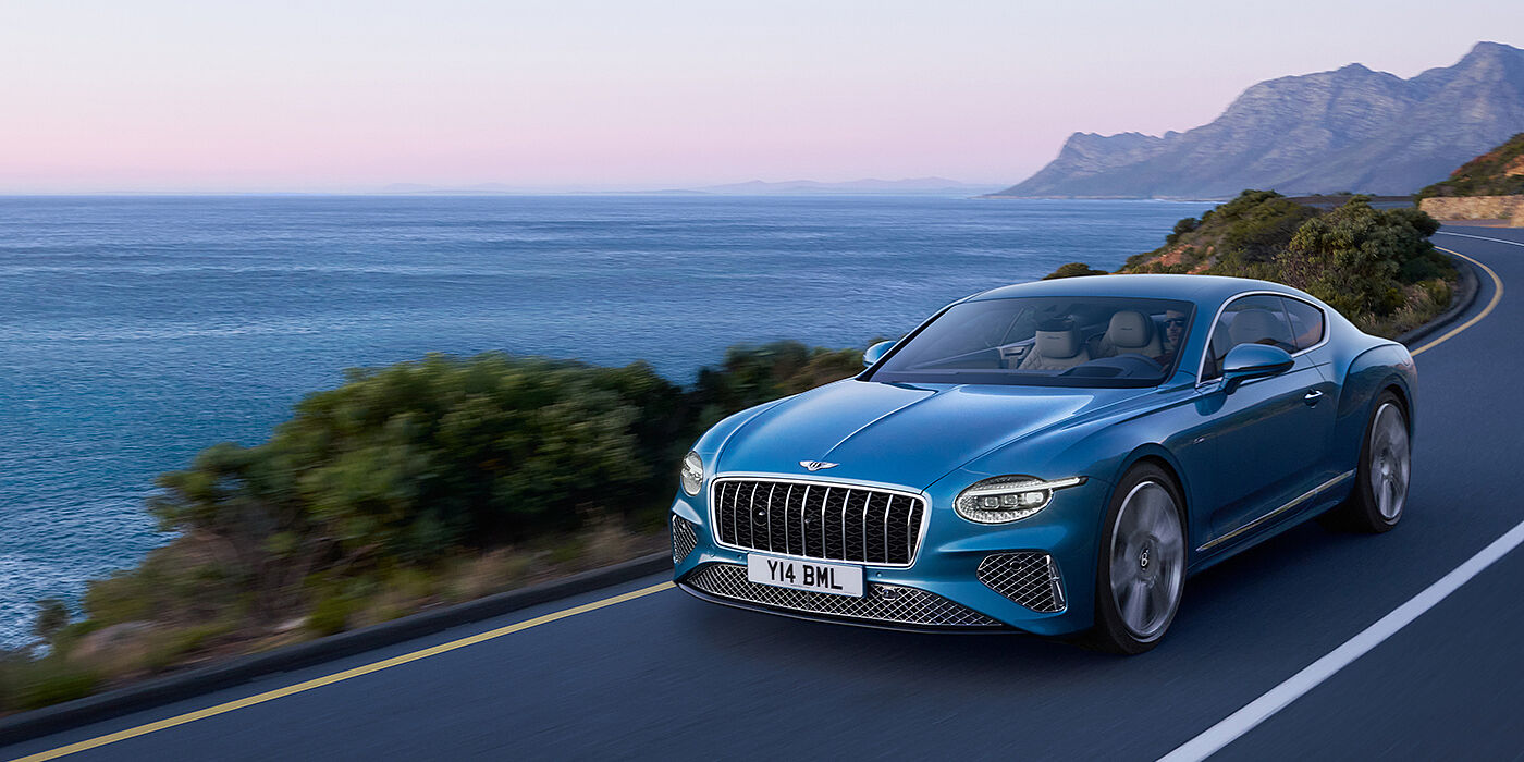 Bentley Kuwait New Bentley Continental GT Azure coupe in Light Windsor blue paint with 22 inch Azure wheels and chrome grill, driving dynamically by the se