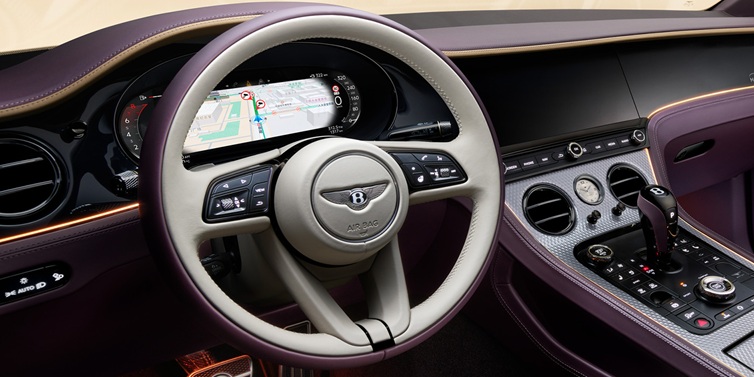 Bentley Kuwait Bentley Continental GT Mulliner coupe front interior showing steering wheel and drivers screens surrounded by Linen and Damson hides and Grand Black veneer